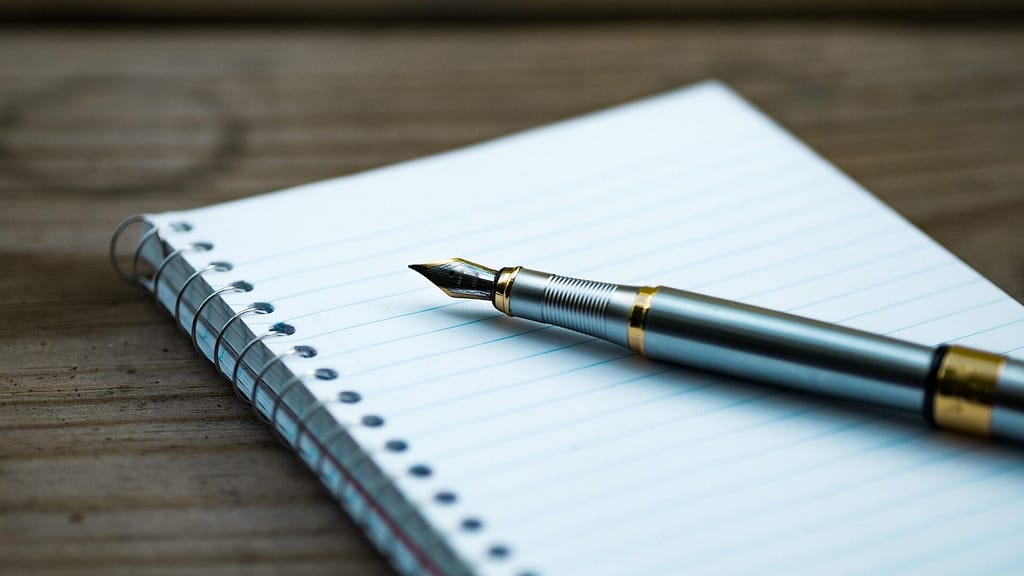 Current image: A fountain pen lying on a blank notebook