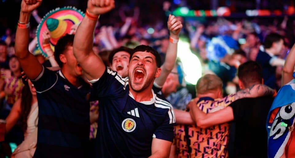 A Scotland football fan cheering in a crowd